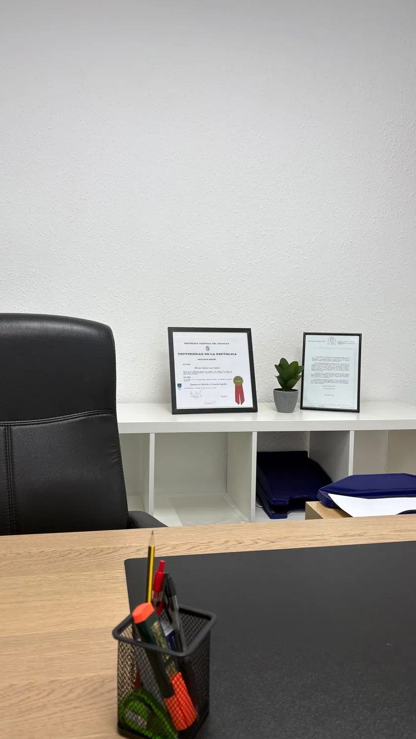 Mesa de despacho con los títulos profesionales enmarcados en la sede de Valencia